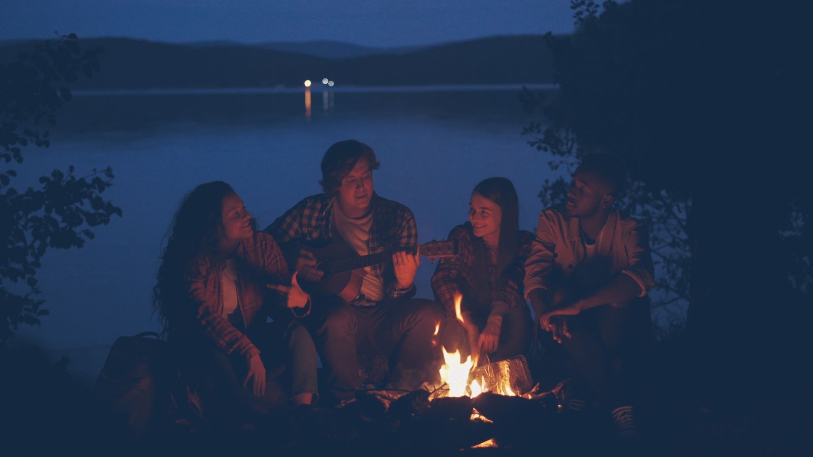 Friends gathered around a fire at night