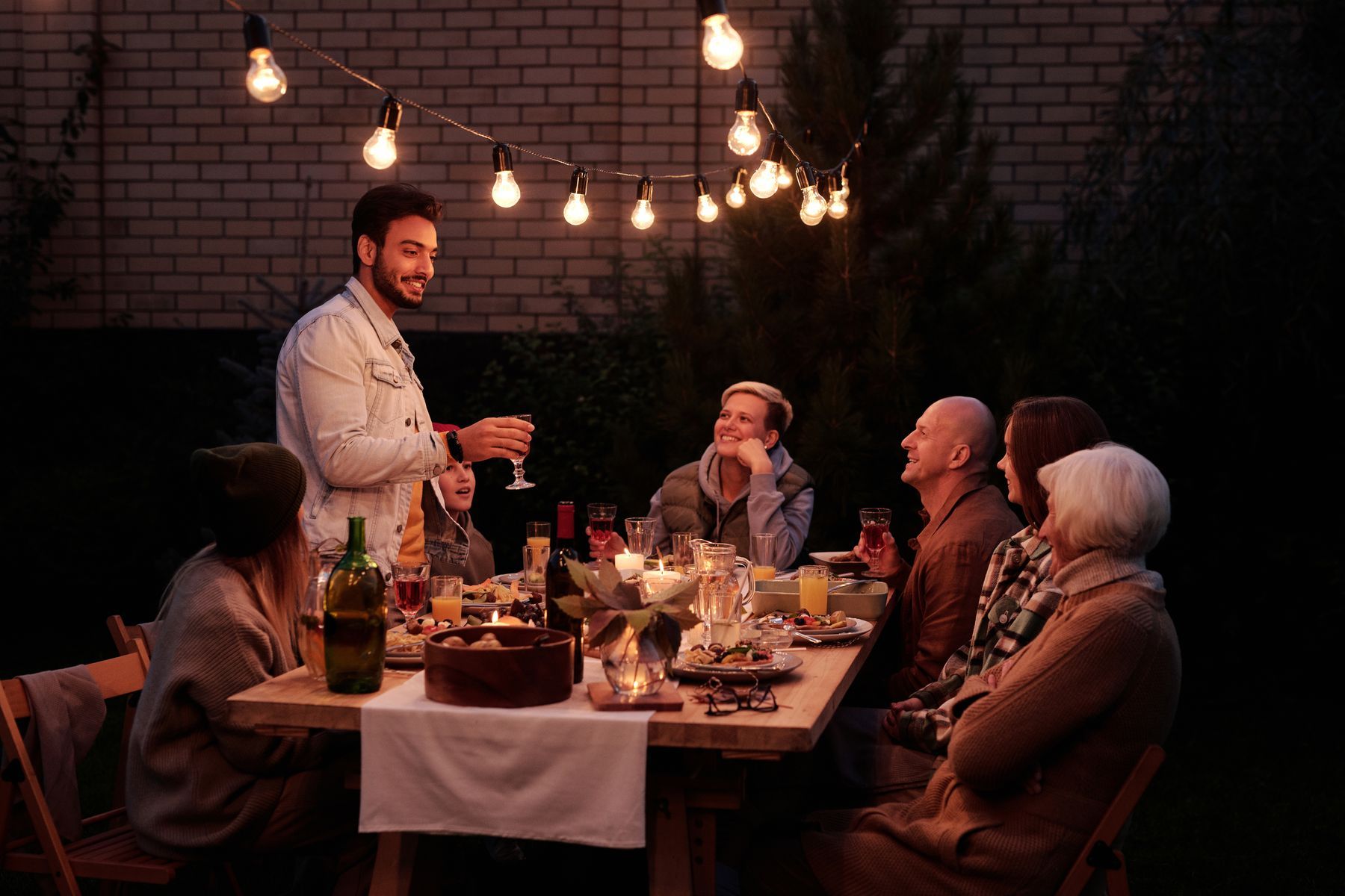 Friends sharing dinner outdoors at night